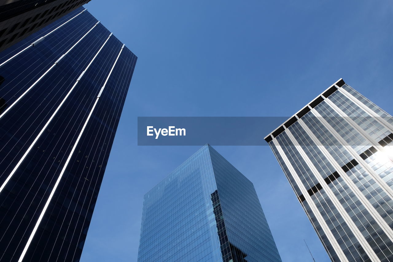 Low angle view of modern buildings against clear blue sky