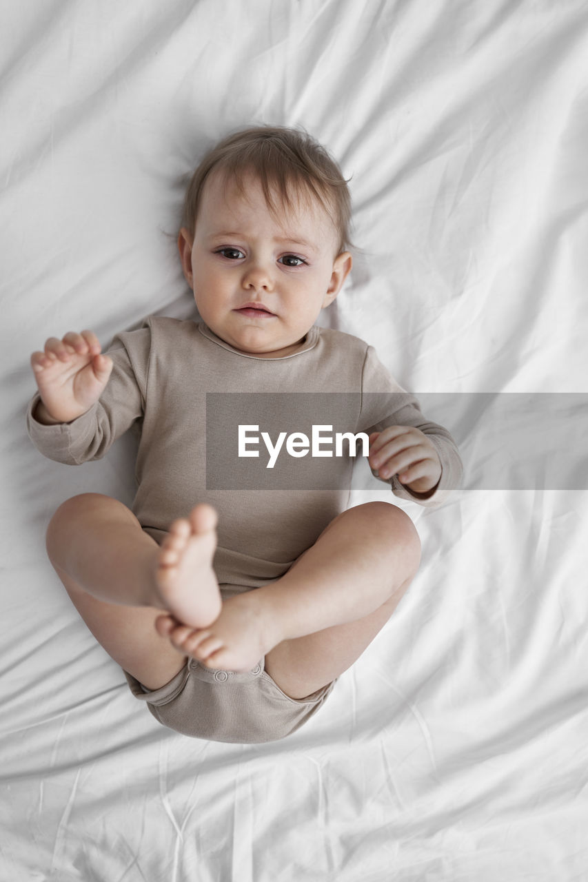 Worried girl lying on bed at home