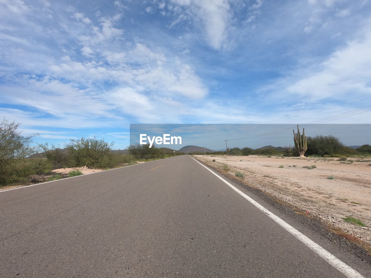 EMPTY ROAD AMIDST LAND AGAINST SKY