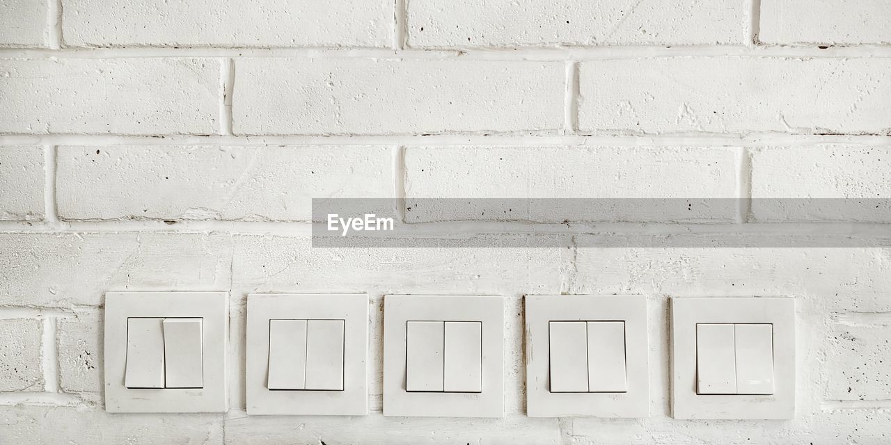 WHITE WALL WITH TEXT ON BRICK WALLS