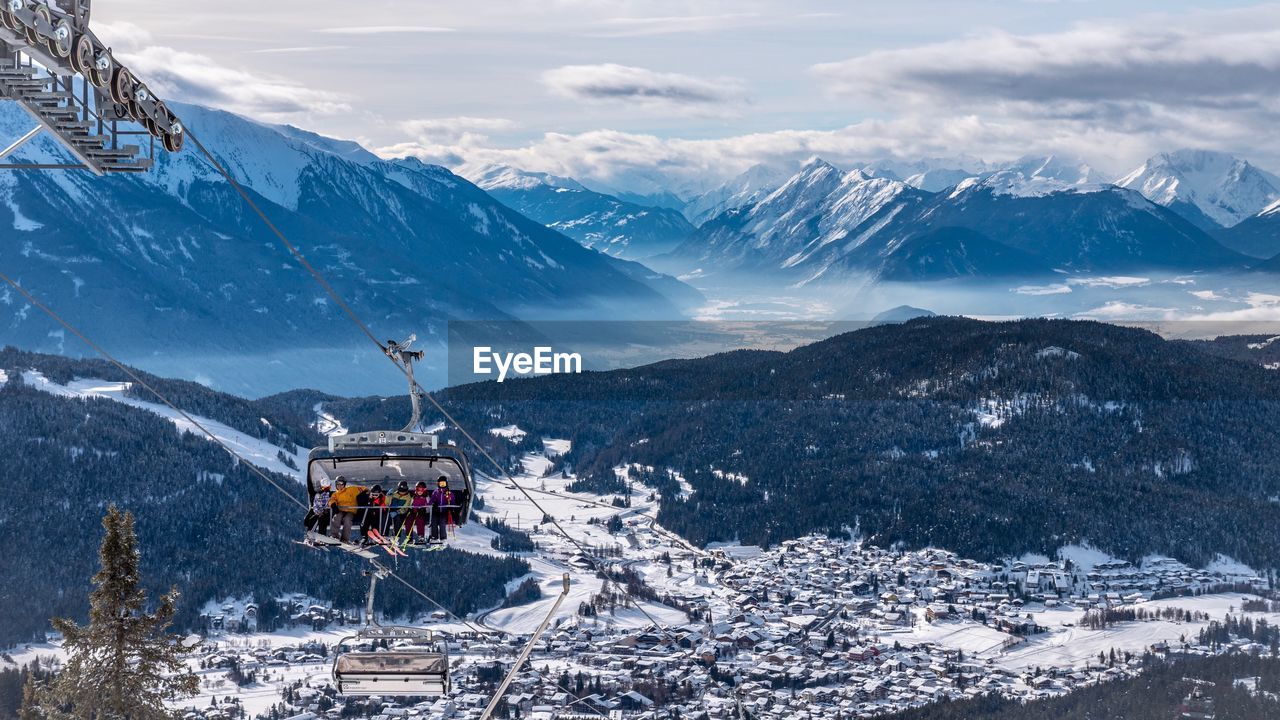 Scenic view of snowcapped mountains against sky with cable car 