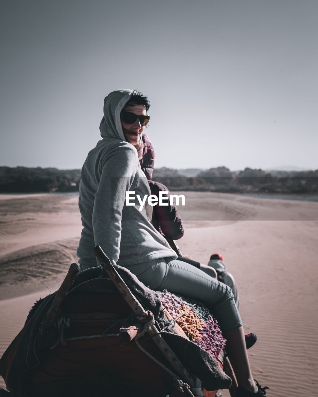 Portrait of mother with daughter riding on camel at desert