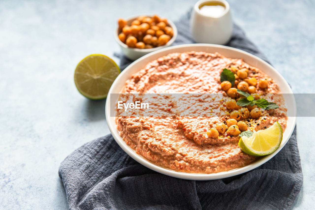 Roasted red pepper hummus garnish with mint and lime. 