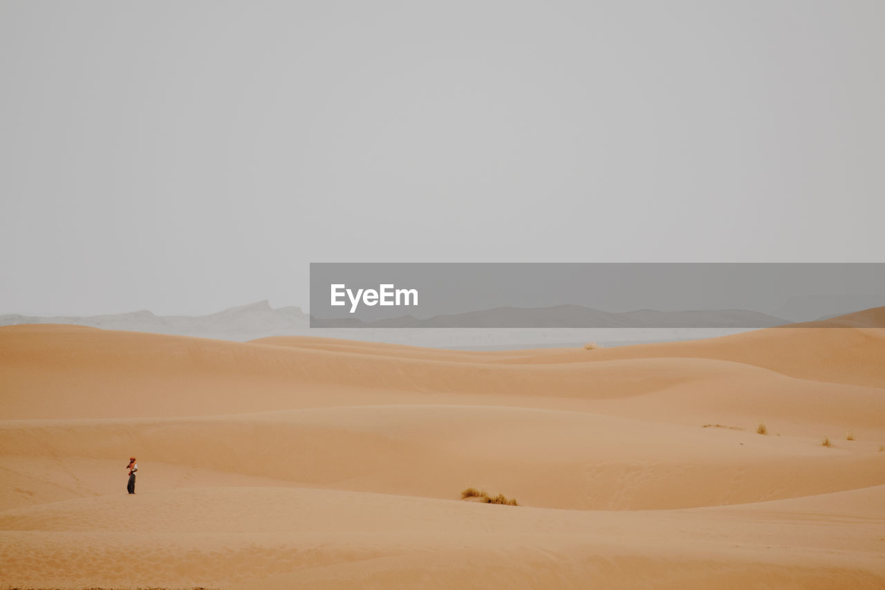 Man standing on desert against sky