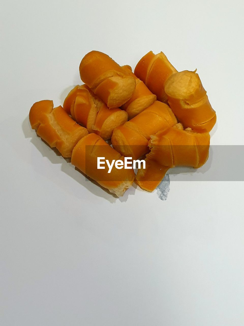 HIGH ANGLE VIEW OF CHOPPED ORANGE ON WHITE BACKGROUND