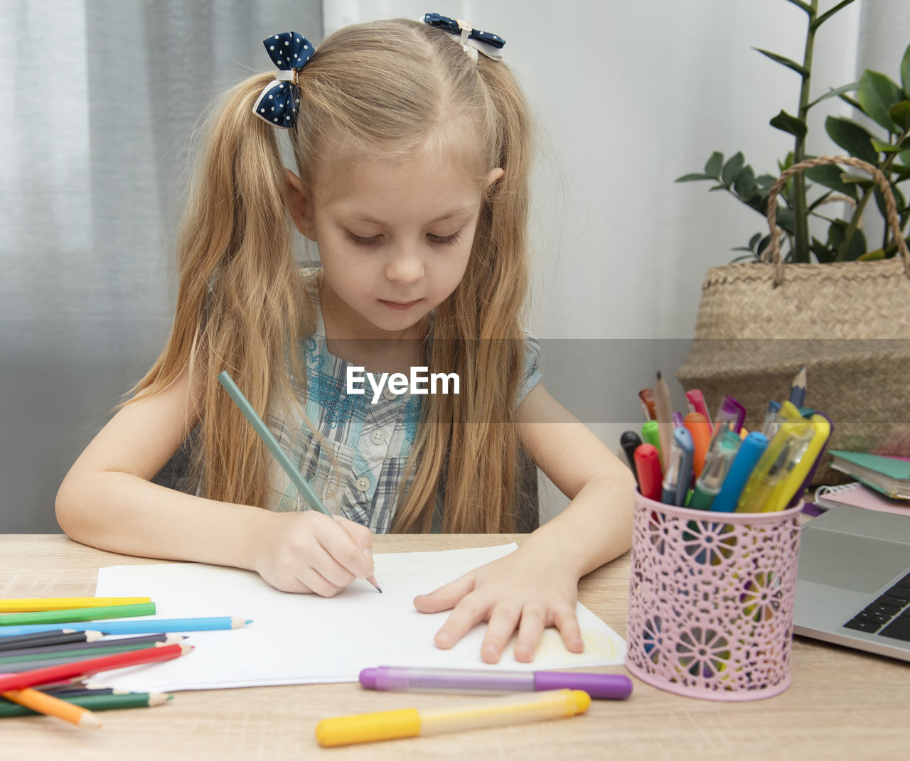 Girl writing in book on table