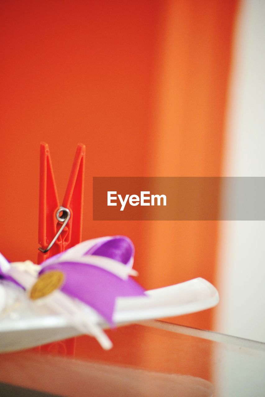 Close-up of clothespin and ribbon on table