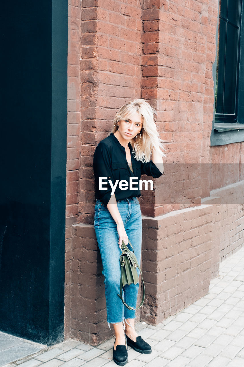 Full length of woman standing by building