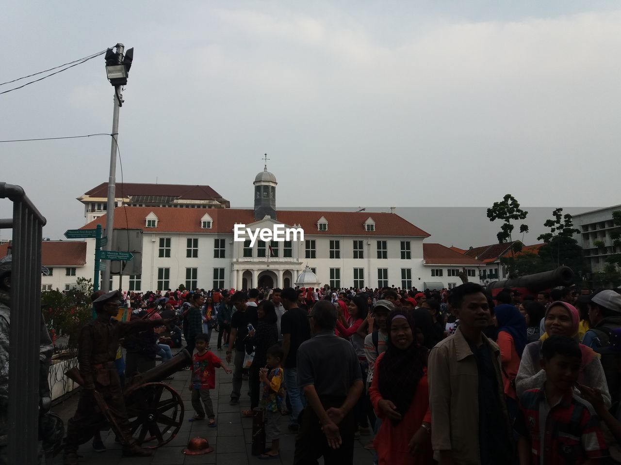 CROWD IN FRONT OF BUILDINGS AGAINST SKY