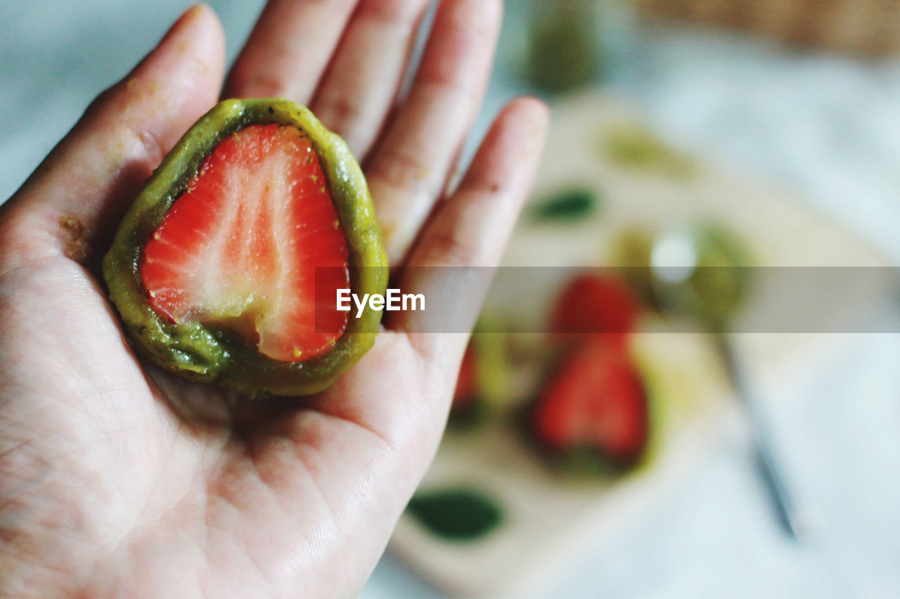 hand, food and drink, food, healthy eating, fruit, holding, wellbeing, freshness, one person, produce, plant, close-up, focus on foreground, indoors, lifestyles, adult, slice, red, finger