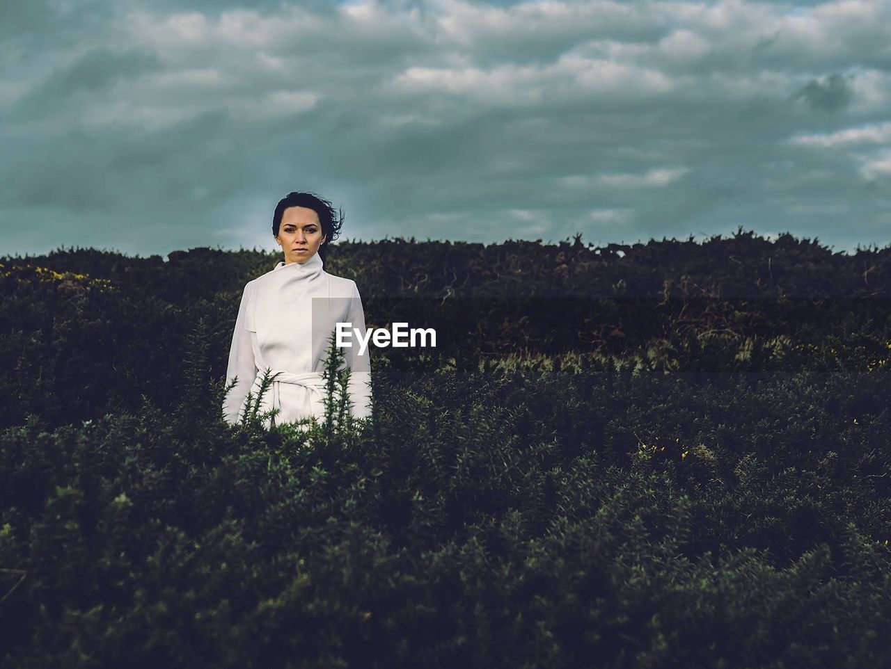 Portrait of woman standing on field against sky