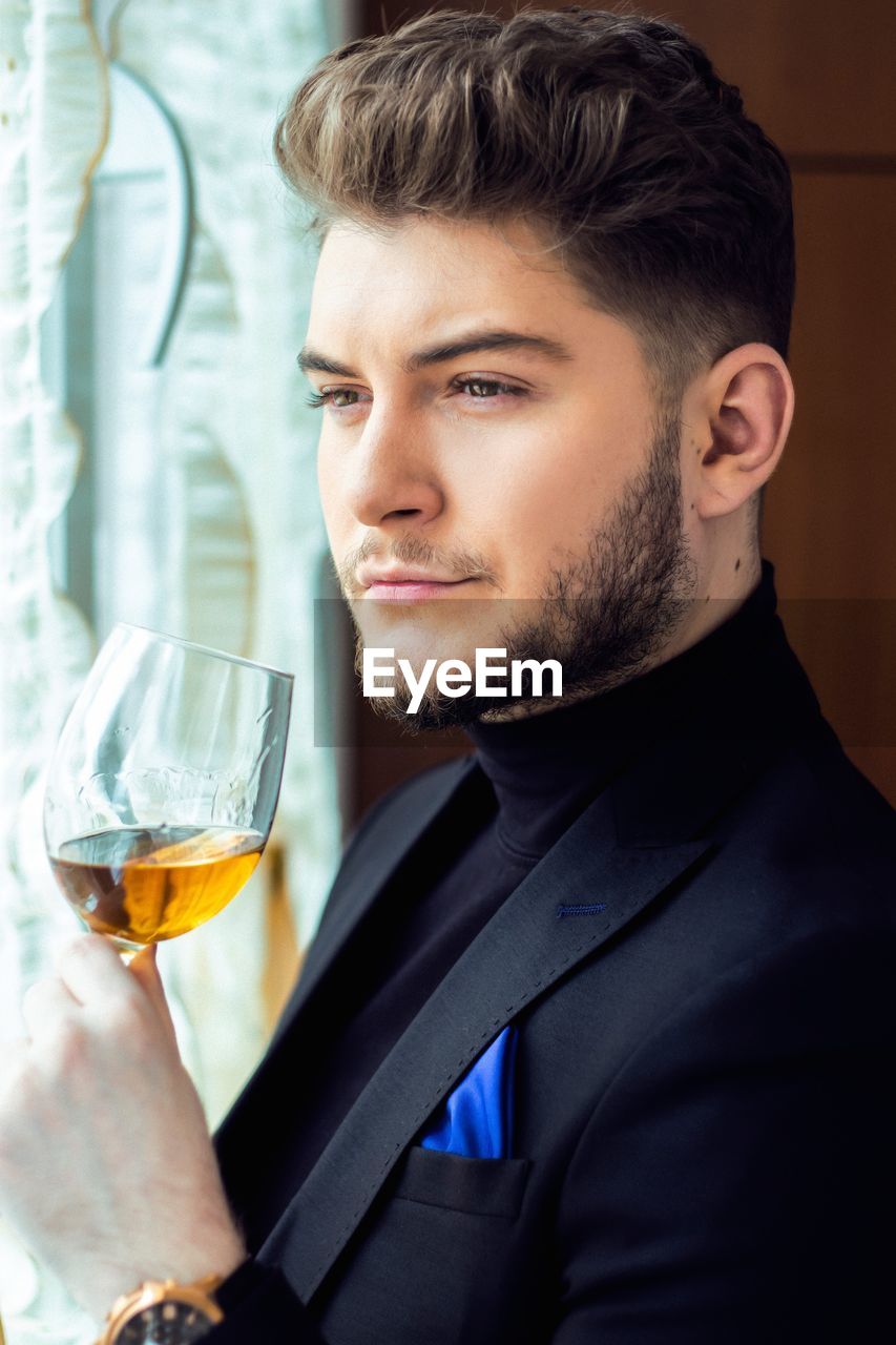 Portrait of a young man drinking glass