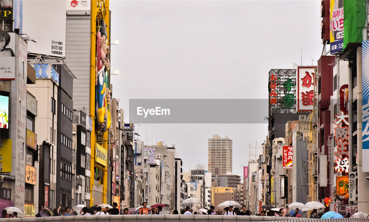 Traffic on road by buildings in city against osaka skyline in japan 