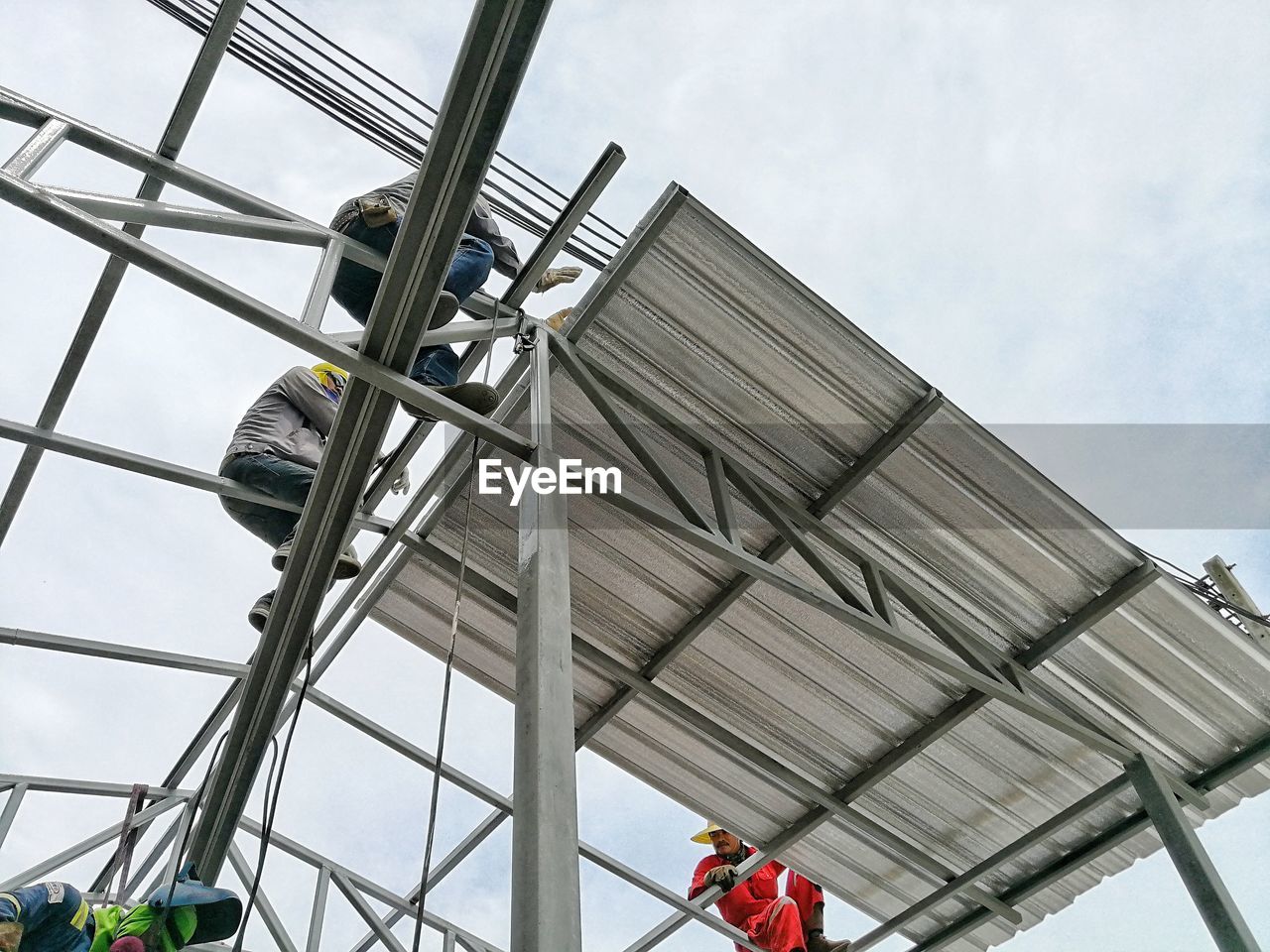 LOW ANGLE VIEW OF PEOPLE WORKING ON CONSTRUCTION SITE