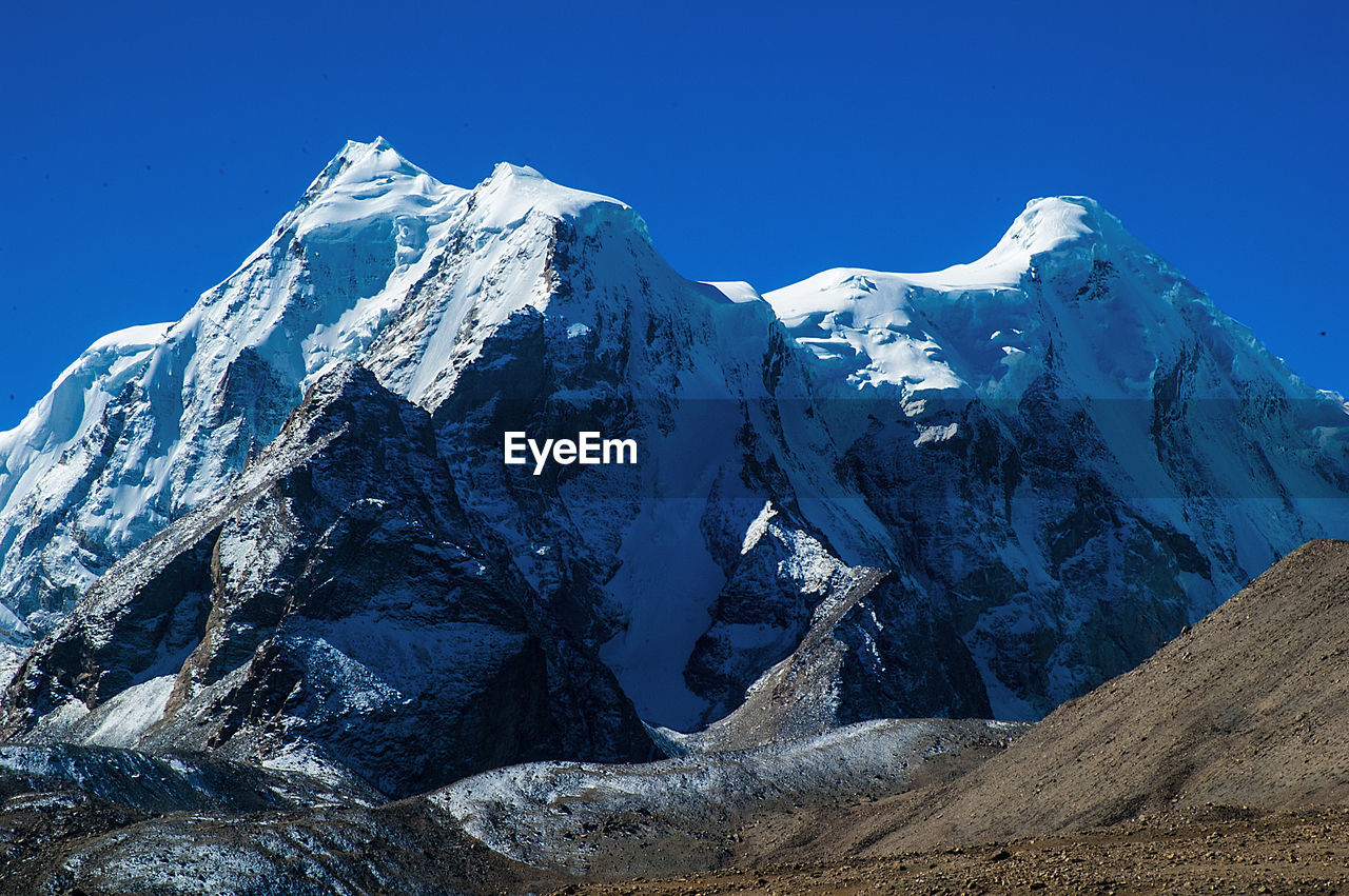 SCENIC VIEW OF SNOWCAPPED MOUNTAIN AGAINST BLUE SKY