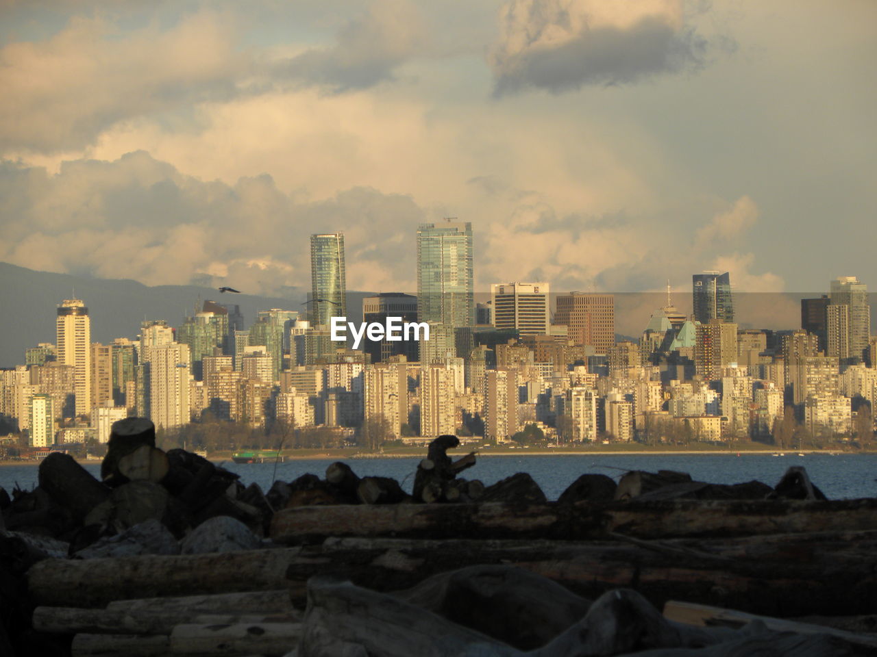 View of city buildings against cloudy sky