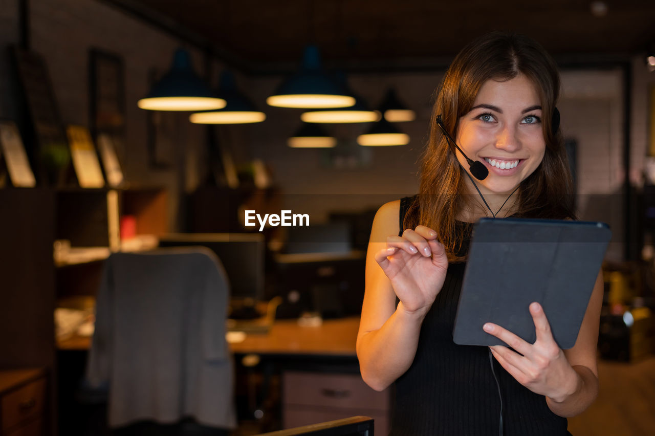 Portrait of smiling young woman digital tablet