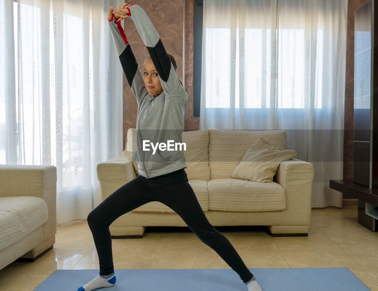 MAN STANDING ON SOFA AT HOME