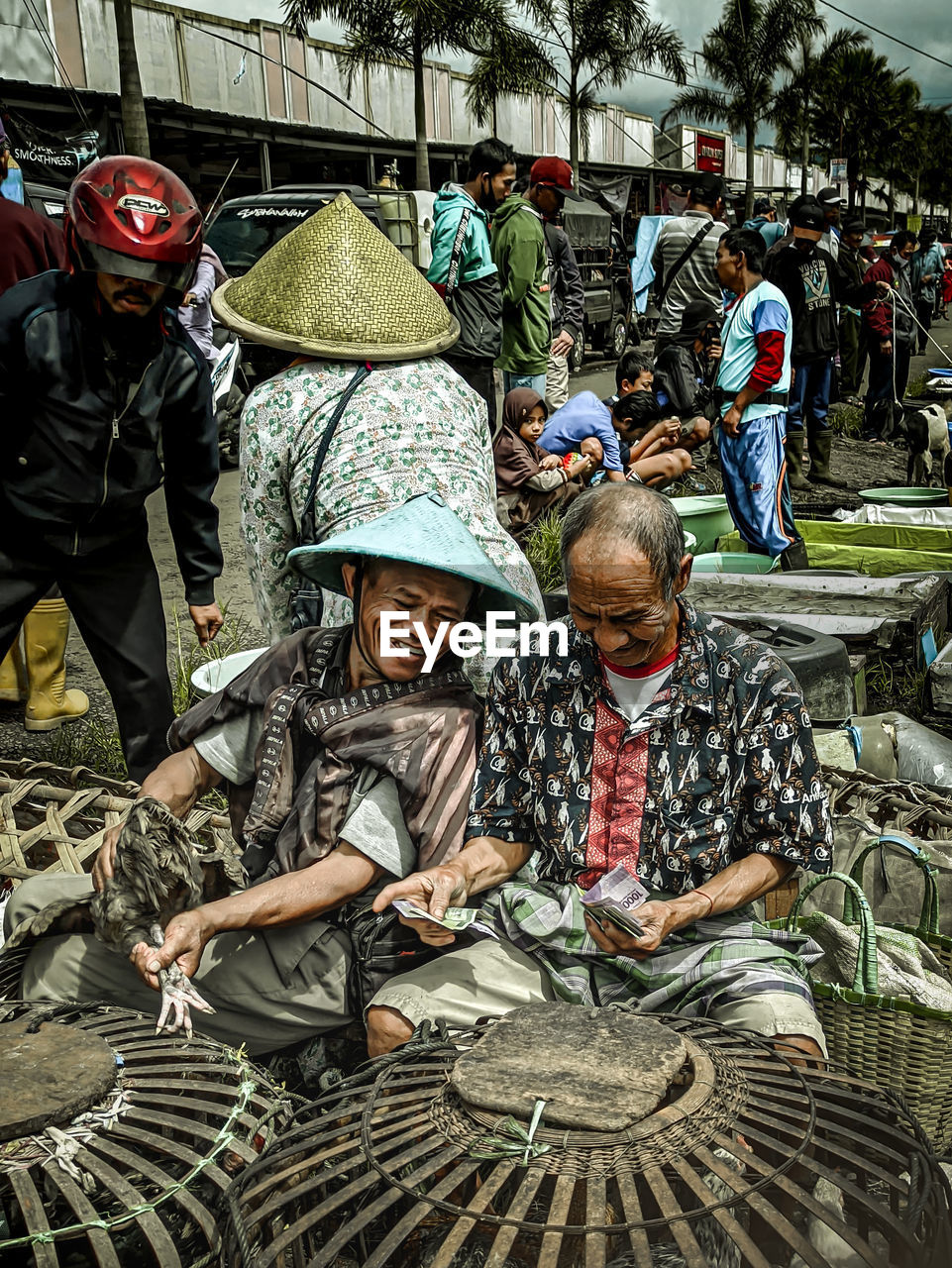 GROUP OF PEOPLE SITTING AT MARKET STALL