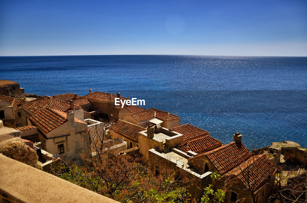 High angle view of townscape by sea against clear sky