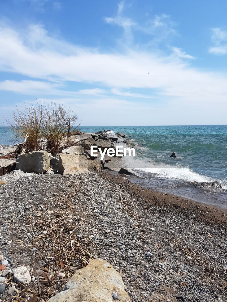 ROCKS ON BEACH AGAINST SKY