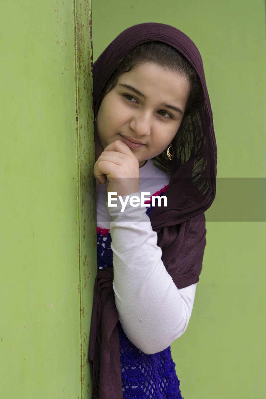 PORTRAIT OF A SMILING YOUNG WOMAN STANDING OUTDOORS