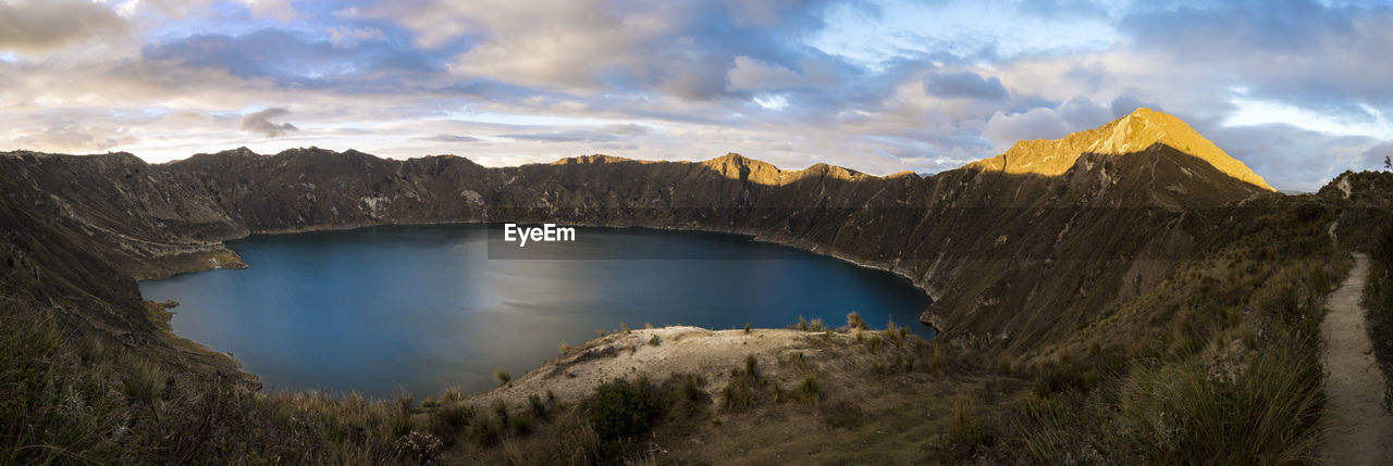 Scenic view of crater lake surrounded by mountains against sky