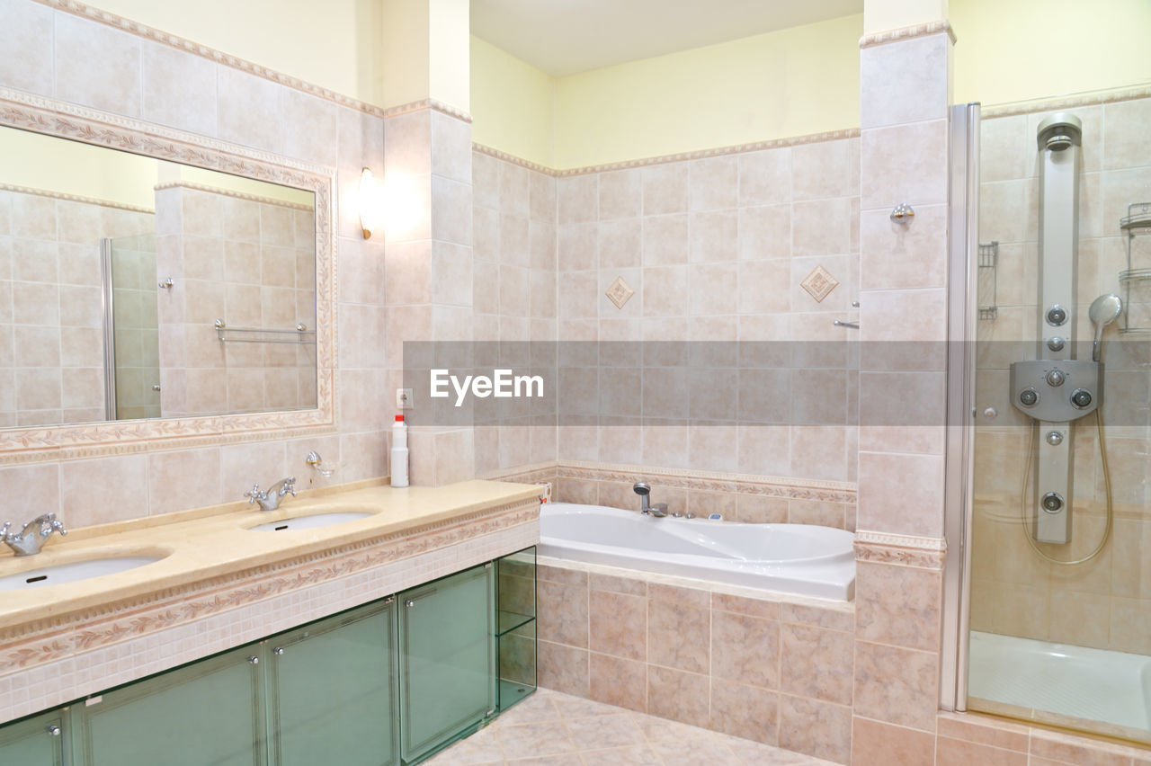 Clean bathroom in a hotel room with bath and shower.