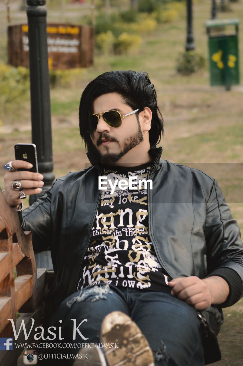 YOUNG MAN USING MOBILE PHONE IN TRADITIONAL CLOTHING