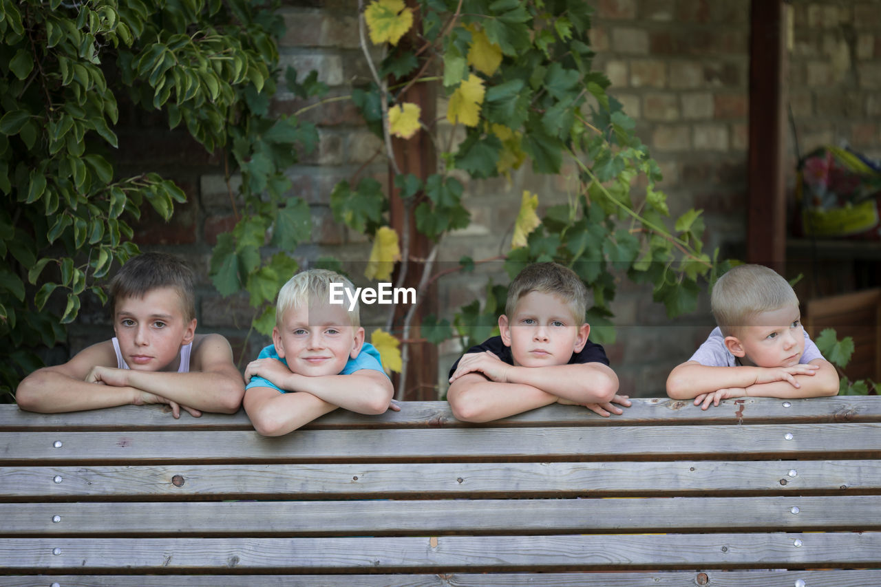 Boys leaning on bench at park