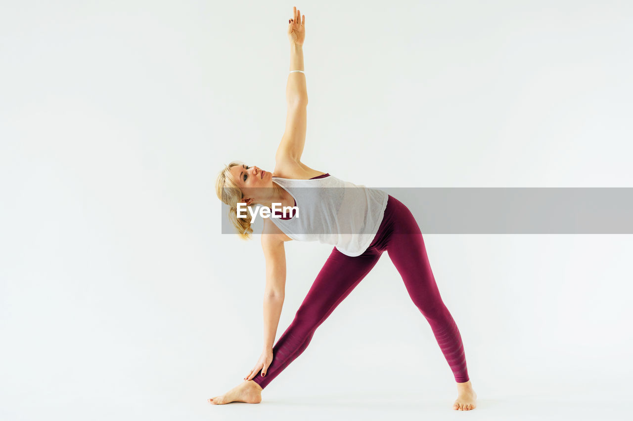 Sporty woman in yoga pose. healthy concentrated woman doing stretching yoga exercises. 