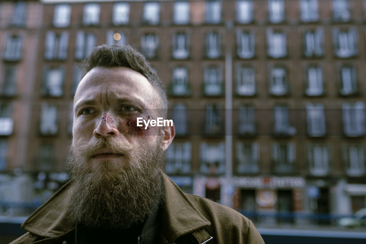 Hipster man with beard and cinema makeup posing on the street