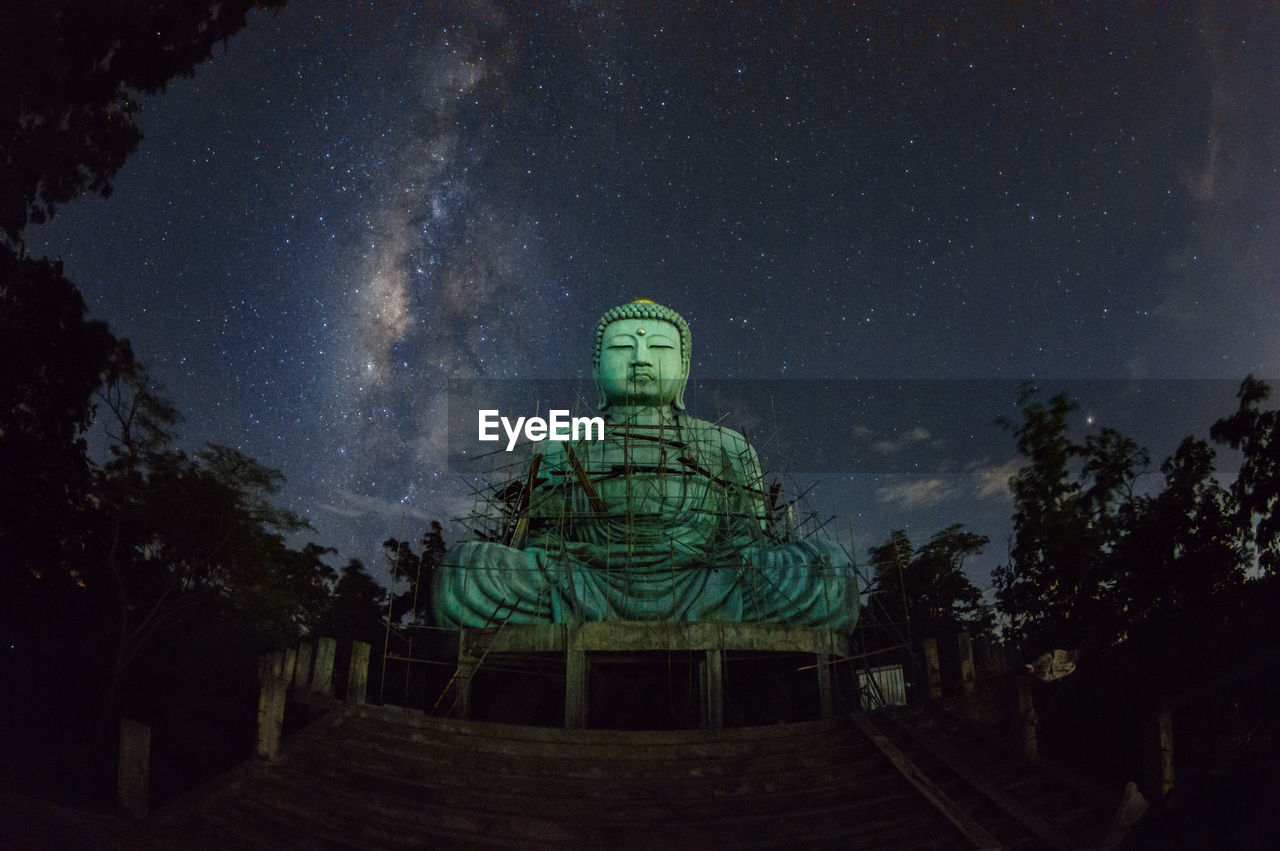 Daibutsu or 'giant buddha' large statue of buddha, with milky way moving in sky.