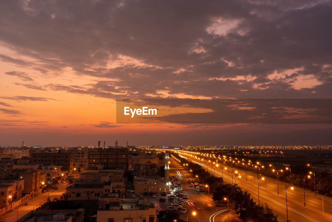 High angle view of illuminated cityscape against sky during sunset