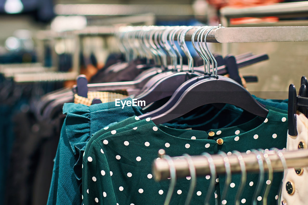 blue, coathanger, retail, clothing, store, fashion, hanging, shopping, rack, business finance and industry, clothing store, in a row, no people, business, focus on foreground, textile, clothes rack, variation, consumerism, sale, indoors