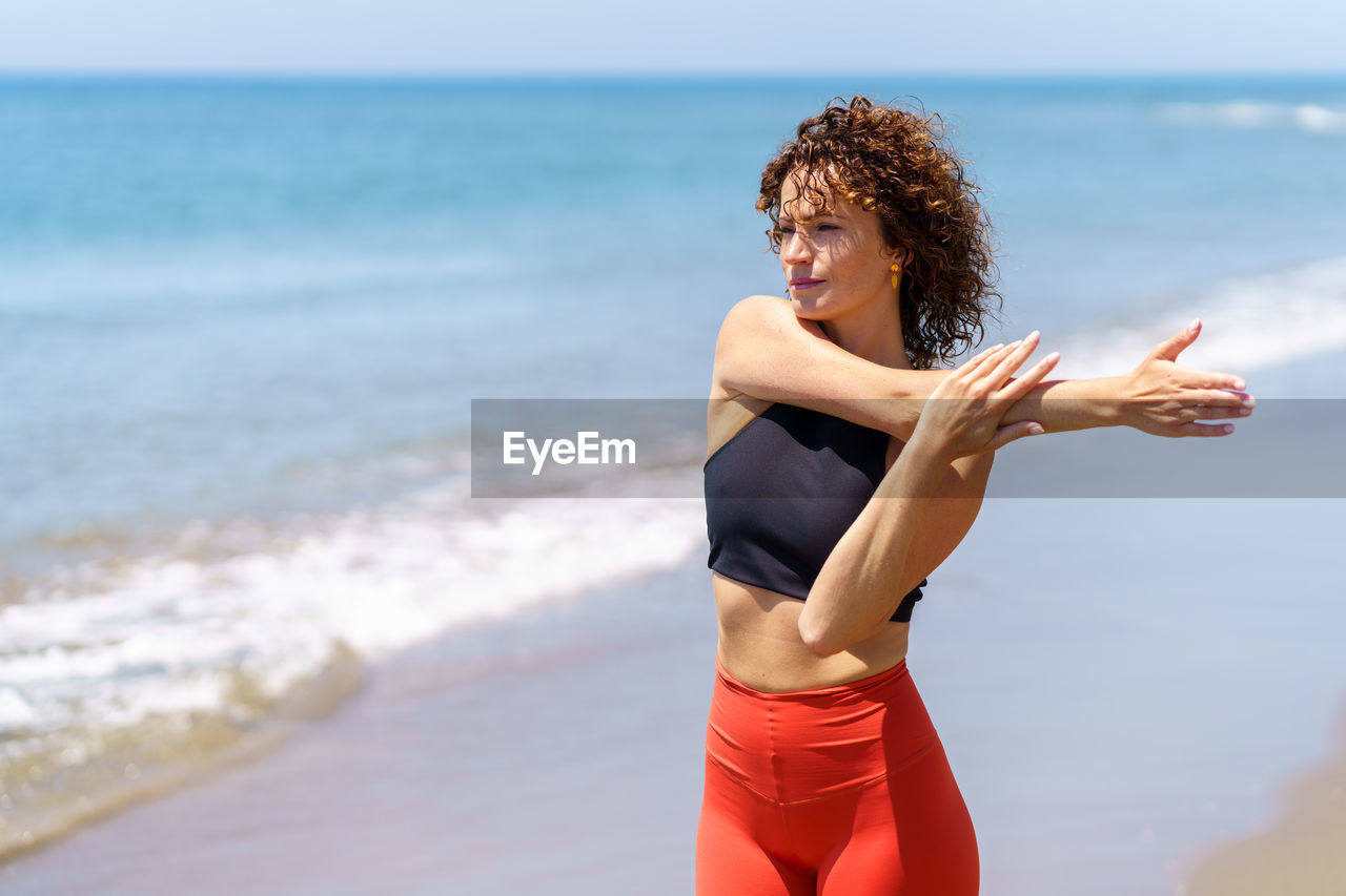 portrait of young woman exercising on beach