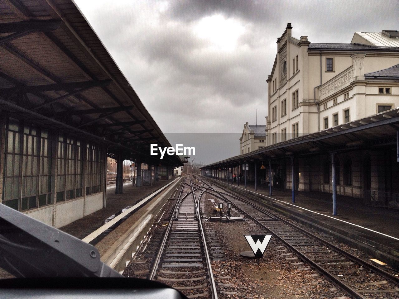 Railroad tracks seen through train windshield at bahnhof zittau against cloudy sky