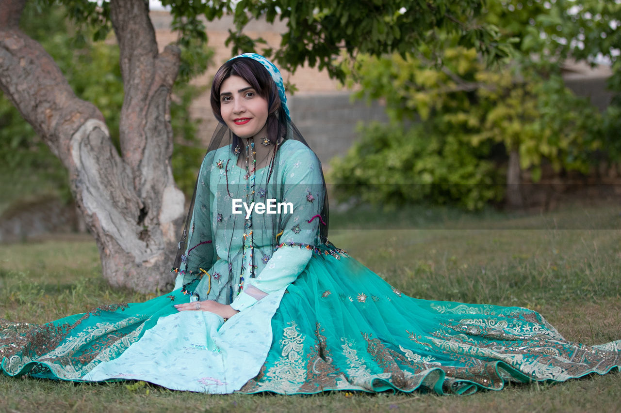 Portrait of smiling young woman sitting outdoors