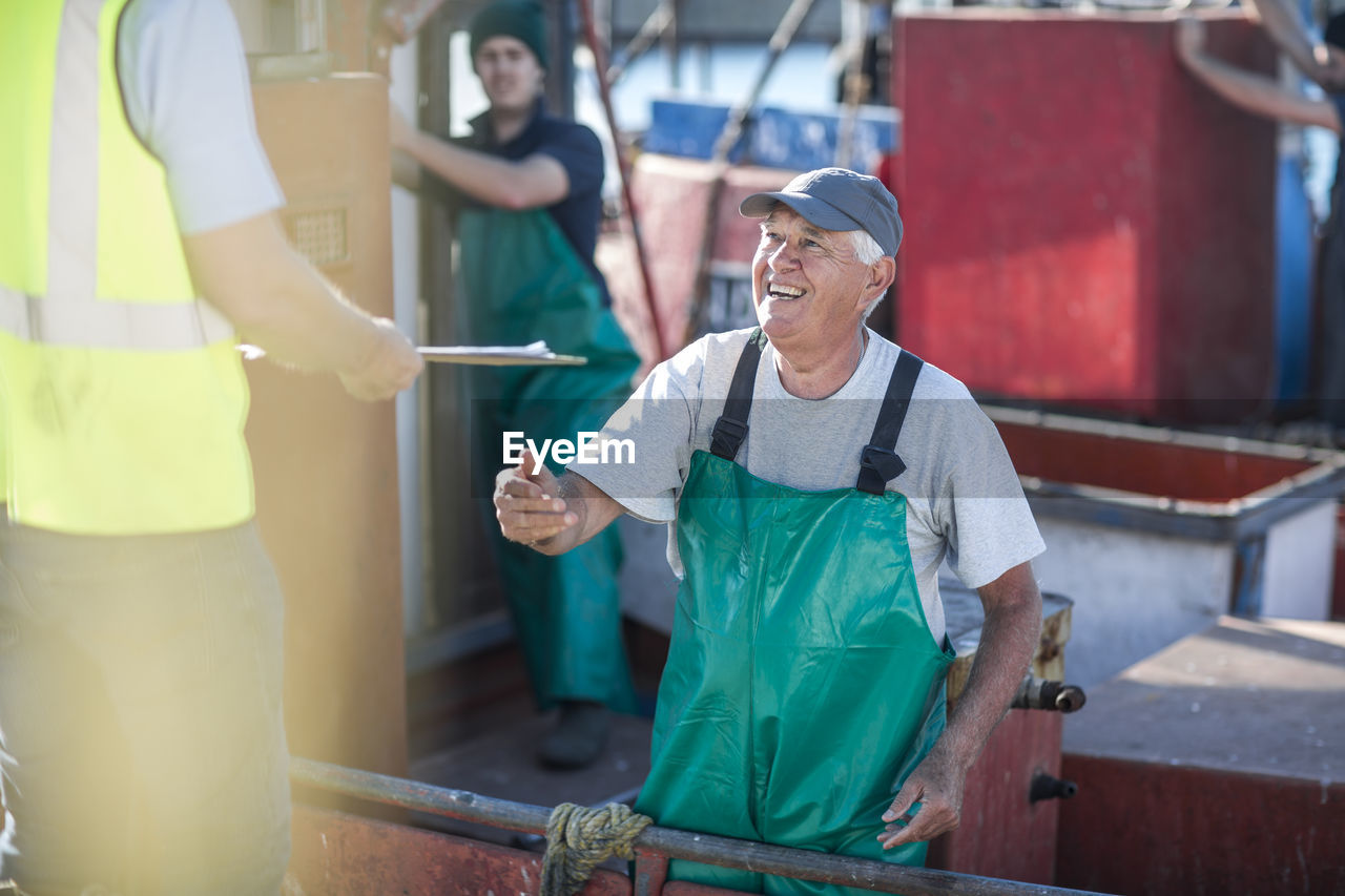 Fisherman on trawler talking to inspector