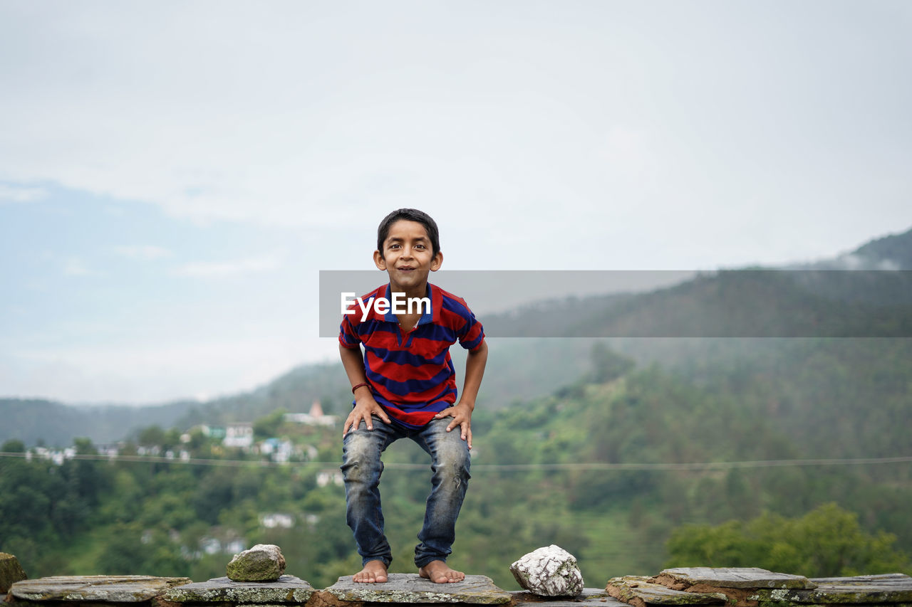 Little indian kid jumping with joy on the roof