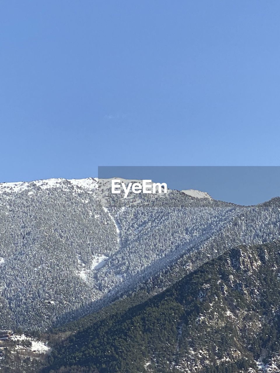 LOW ANGLE VIEW OF SNOWCAPPED MOUNTAIN AGAINST CLEAR SKY