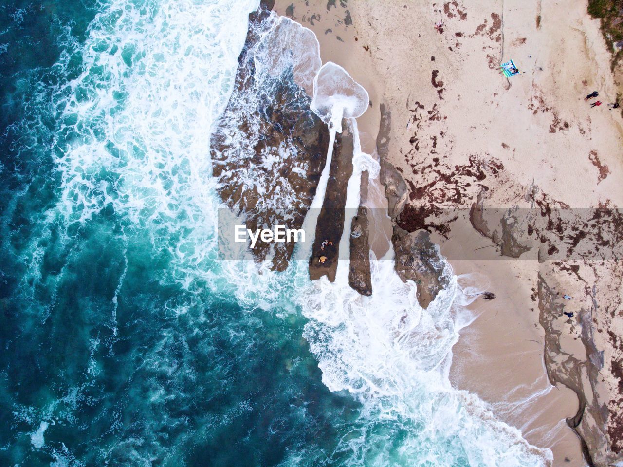 Aerial view of sea waves flowing on shore at beach
