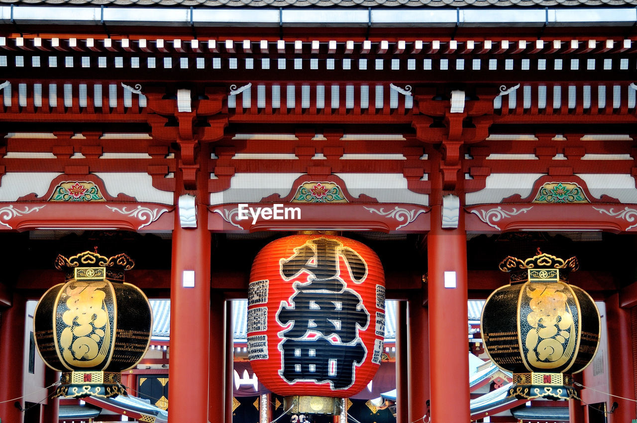 ILLUMINATED LANTERNS HANGING BY BUILDING