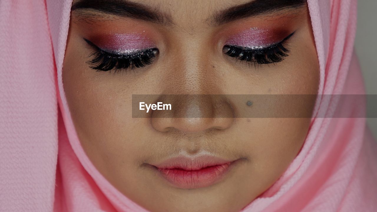 CLOSE-UP PORTRAIT OF BEAUTIFUL WOMAN WITH PINK PETALS