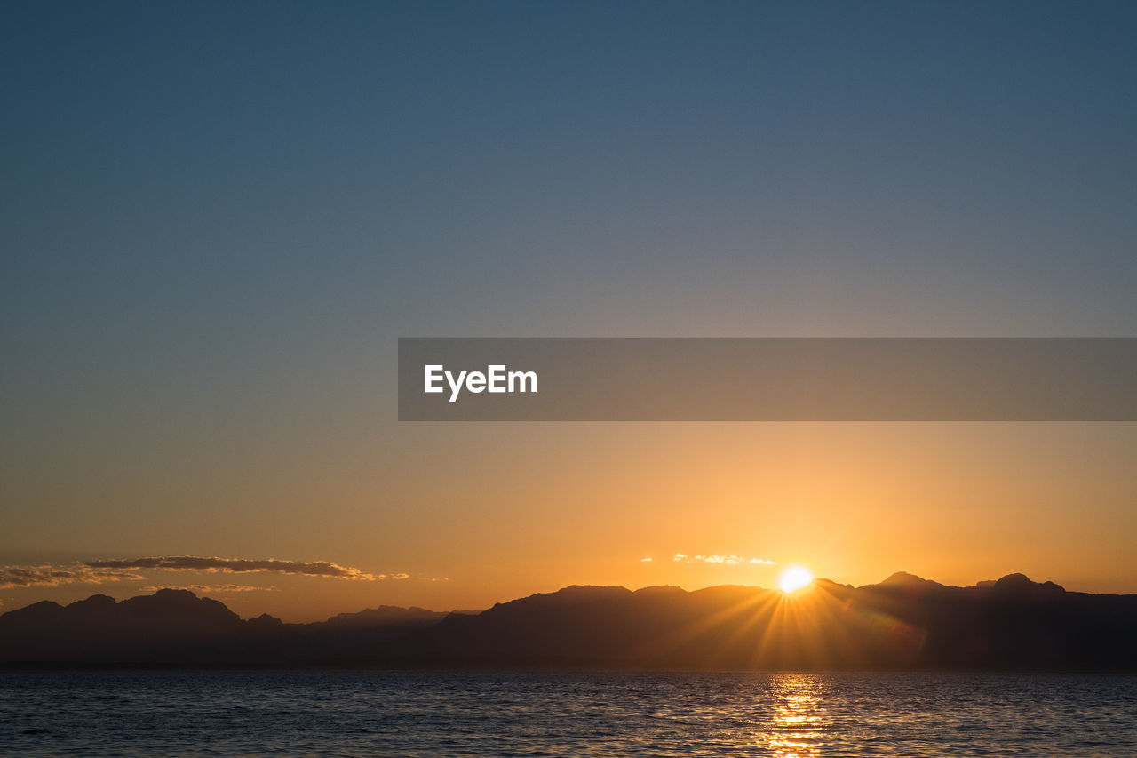 Scenic view of silhouette mountains against sky during sunset