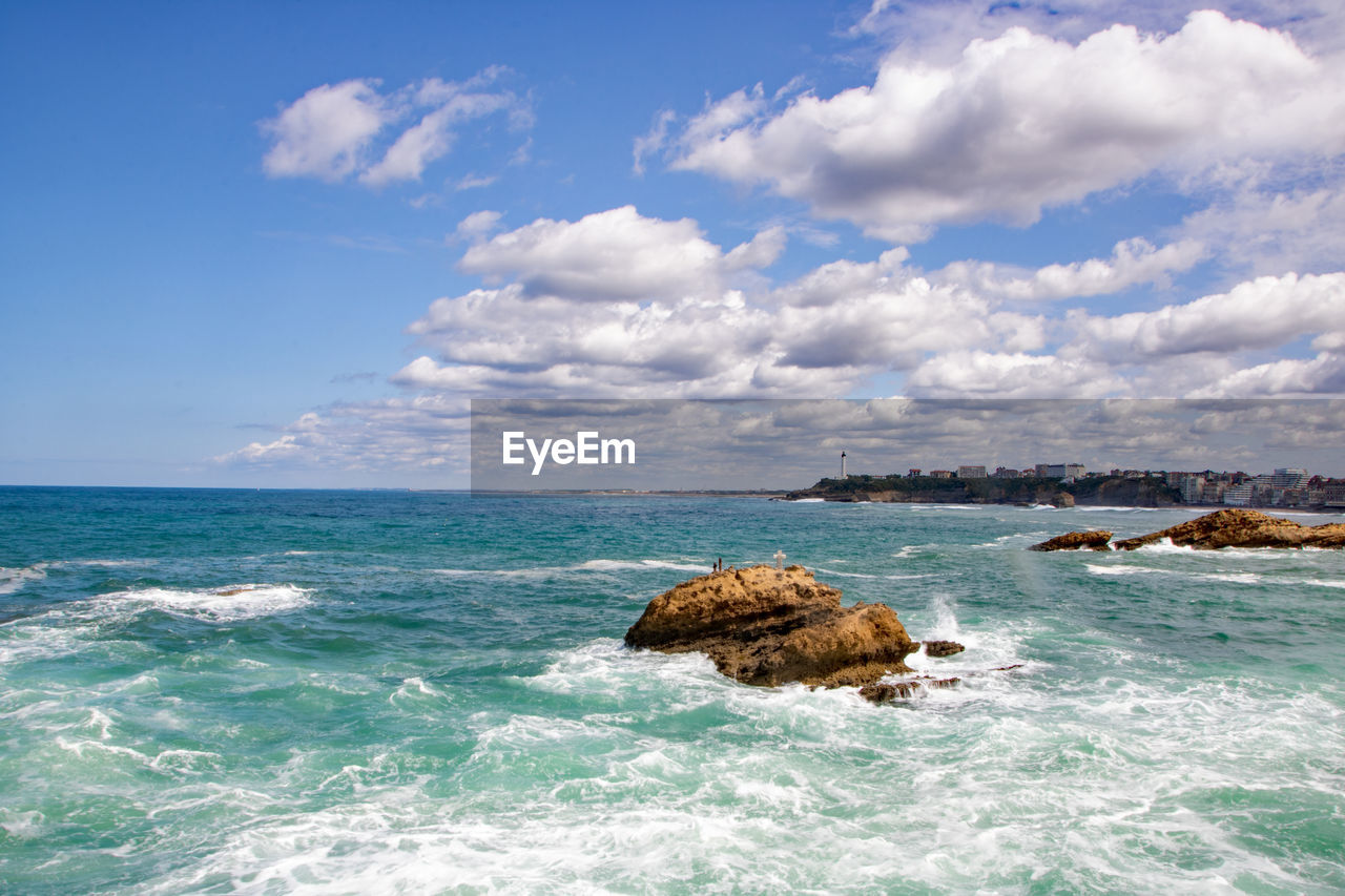 ROCKS ON SEA SHORE AGAINST SKY