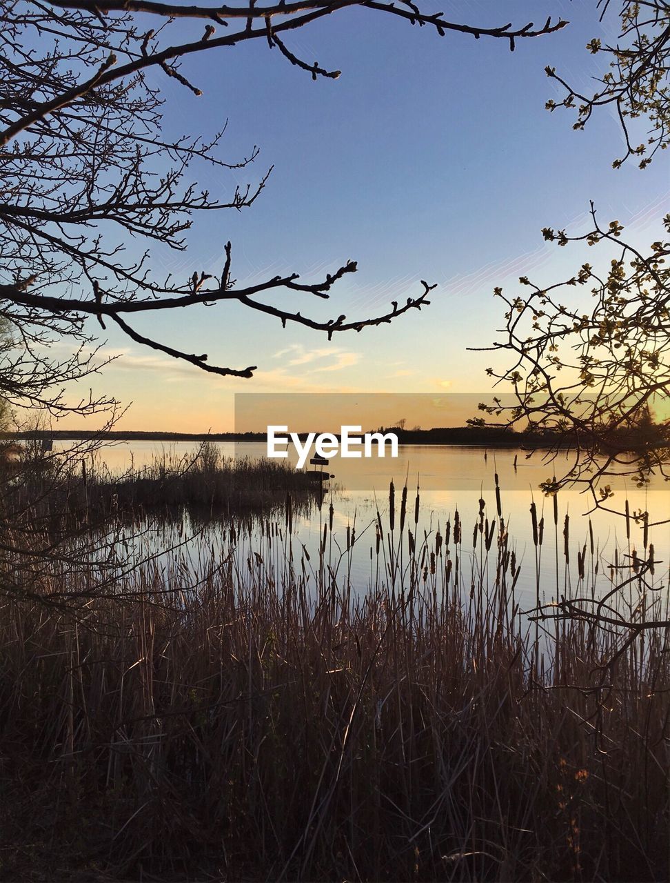 SCENIC VIEW OF LAKE AGAINST SUNSET SKY