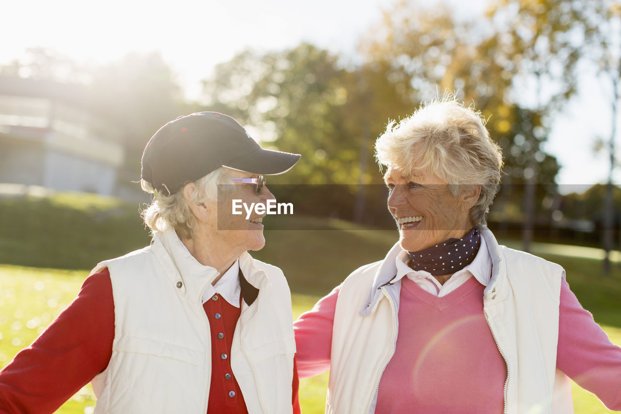 Senior female golfers looking at each other on golf course