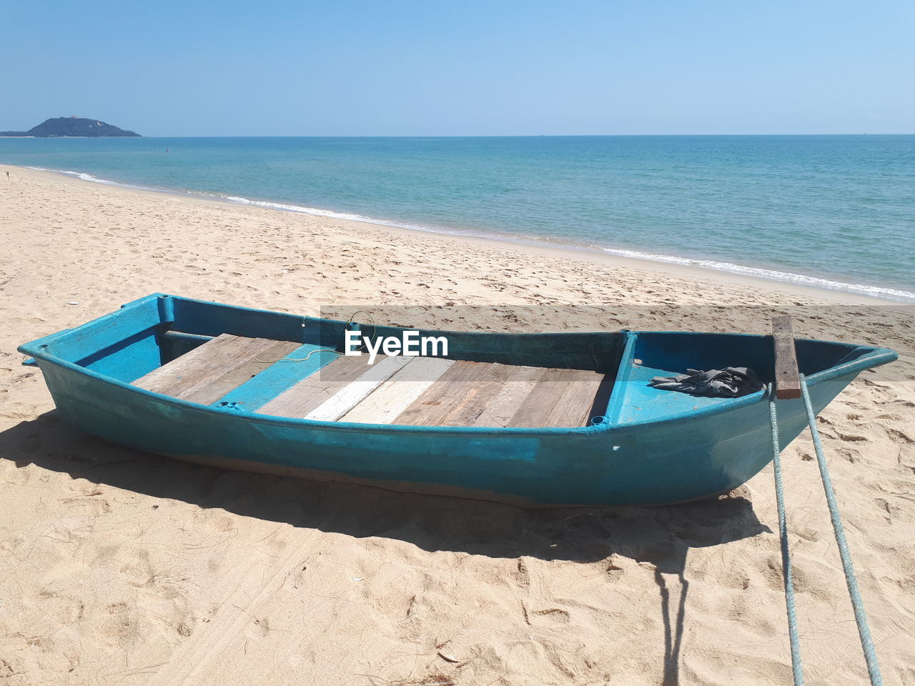 BOAT MOORED ON SHORE AGAINST SKY