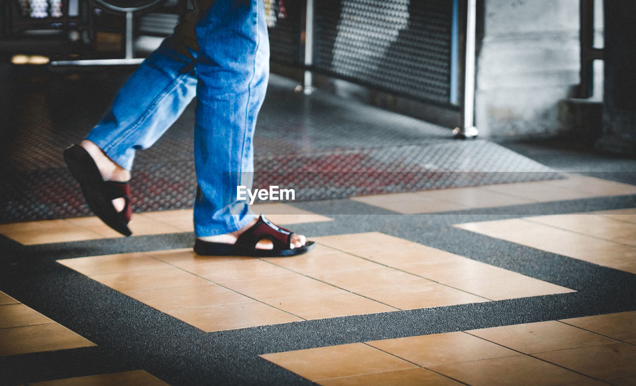 Low section of man walking on footpath